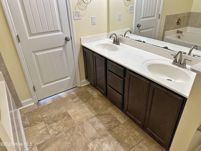 full bathroom featuring a sink, double vanity, and a bath