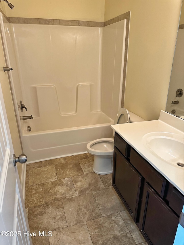 bathroom featuring tub / shower combination, stone finish floor, and vanity