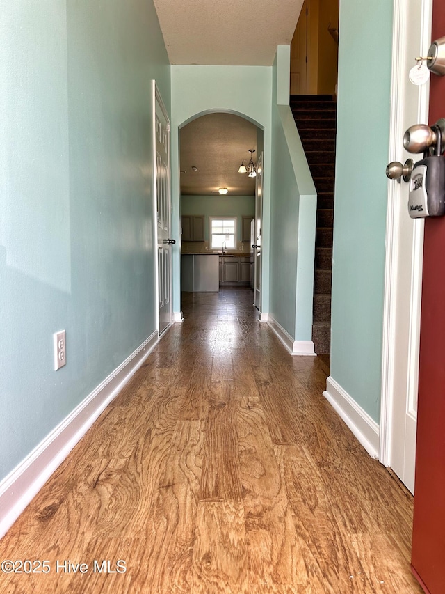 corridor with arched walkways and baseboards