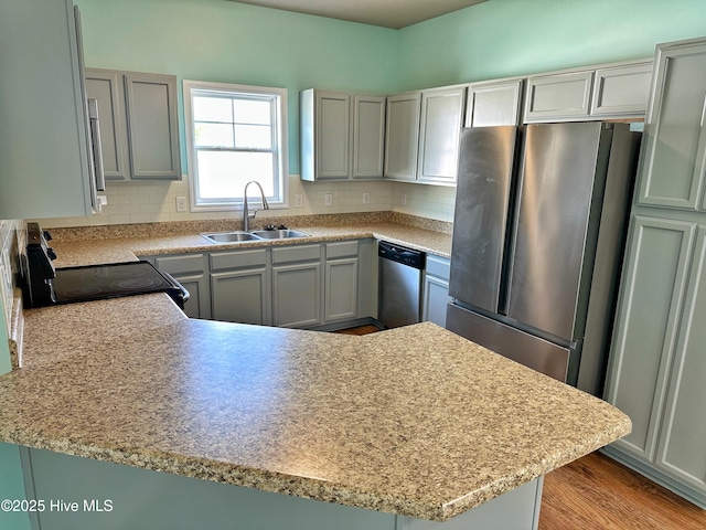 kitchen with a sink, decorative backsplash, appliances with stainless steel finishes, and light countertops