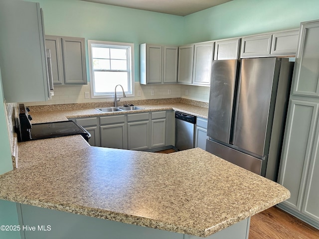 kitchen featuring light countertops, a sink, decorative backsplash, and stainless steel appliances