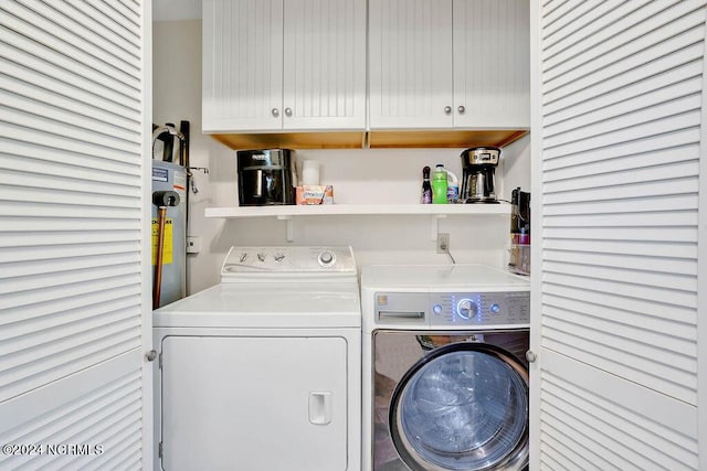 laundry room featuring cabinet space, water heater, and washing machine and clothes dryer