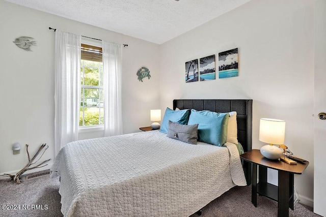 carpeted bedroom with visible vents and a textured ceiling