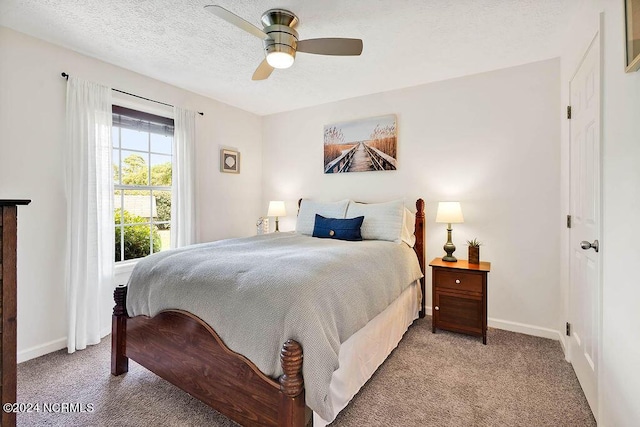 bedroom featuring a ceiling fan, light colored carpet, baseboards, and a textured ceiling