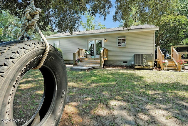 back of property with a wooden deck, a lawn, cooling unit, french doors, and crawl space