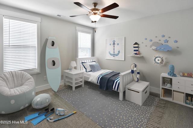 carpeted bedroom with visible vents, baseboards, and ceiling fan