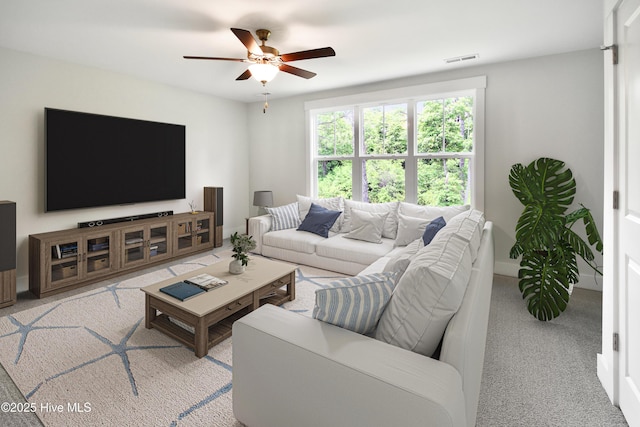 living area with visible vents, light colored carpet, baseboards, and a ceiling fan