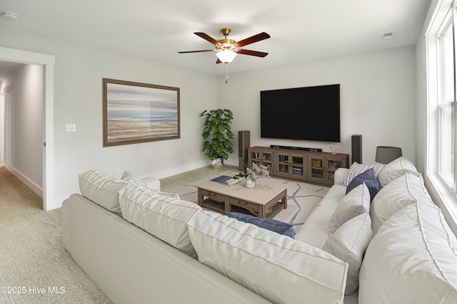 carpeted living area featuring a ceiling fan, baseboards, and visible vents