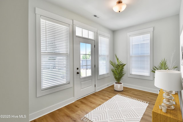 entryway featuring visible vents, wood finished floors, and baseboards