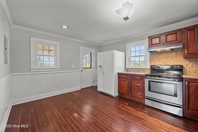 kitchen featuring stainless steel electric range oven, white refrigerator with ice dispenser, a healthy amount of sunlight, and under cabinet range hood