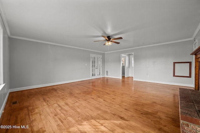 empty room featuring light wood finished floors, visible vents, crown molding, baseboards, and a ceiling fan