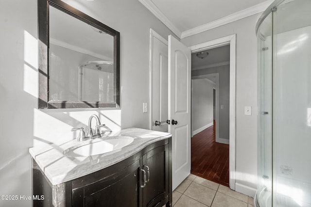 bathroom with crown molding, baseboards, tile patterned floors, vanity, and a shower