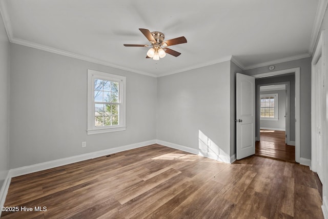 spare room featuring wood finished floors, baseboards, and ornamental molding