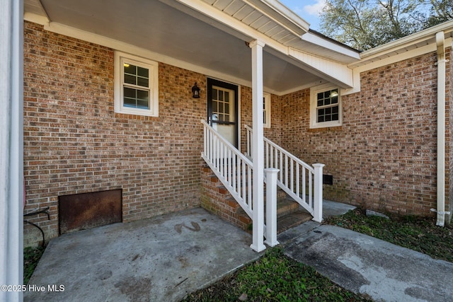 view of exterior entry featuring brick siding