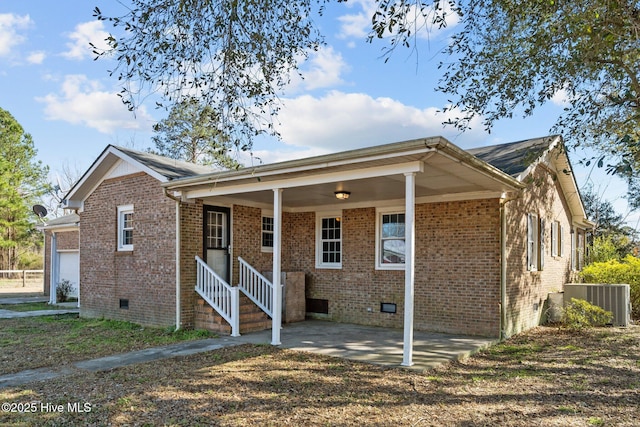 view of front of house with crawl space, a patio area, brick siding, and central AC