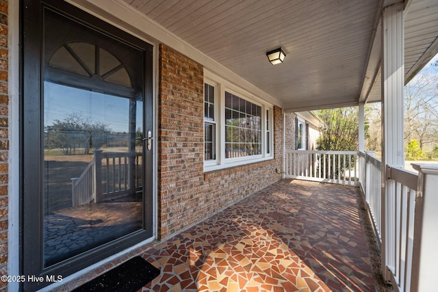 exterior space featuring brick siding and a porch