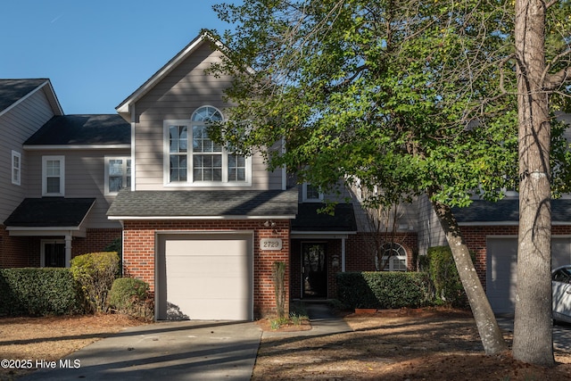 view of front of home featuring a garage, brick siding, driveway, and a shingled roof