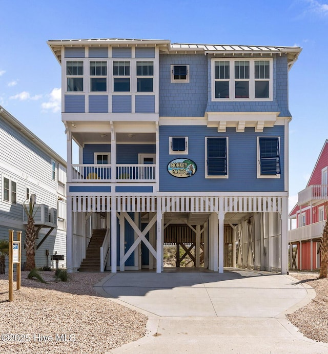 beach home featuring concrete driveway and a carport