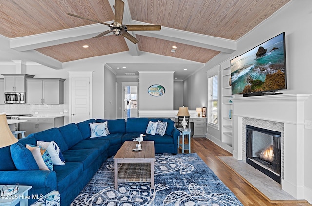 living room featuring ceiling fan, a fireplace with flush hearth, a healthy amount of sunlight, and wood finished floors