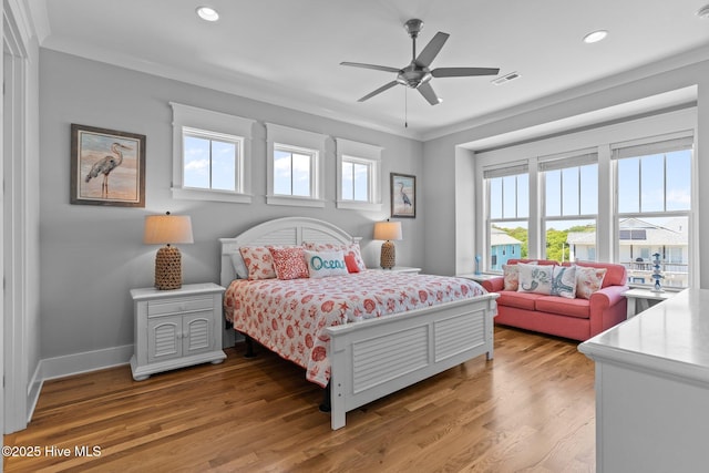 bedroom featuring visible vents, ornamental molding, light wood-style floors, baseboards, and recessed lighting