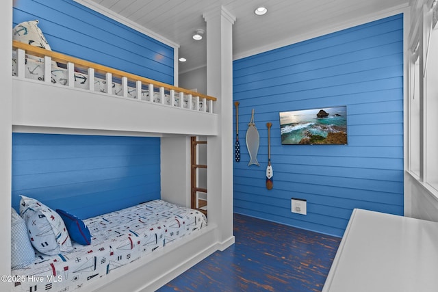bedroom with recessed lighting, wood walls, and wood finished floors