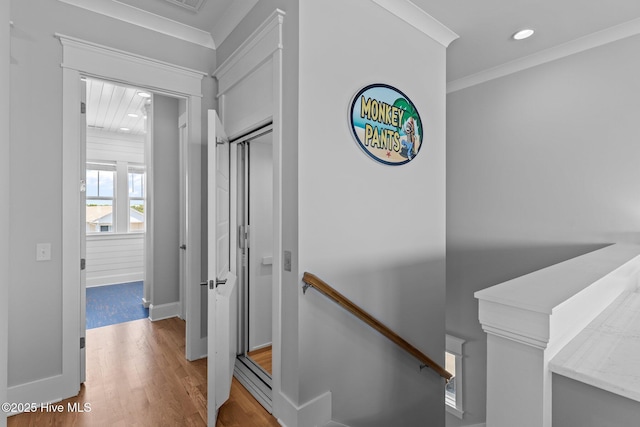 corridor with wood finished floors, baseboards, an upstairs landing, ornamental molding, and recessed lighting