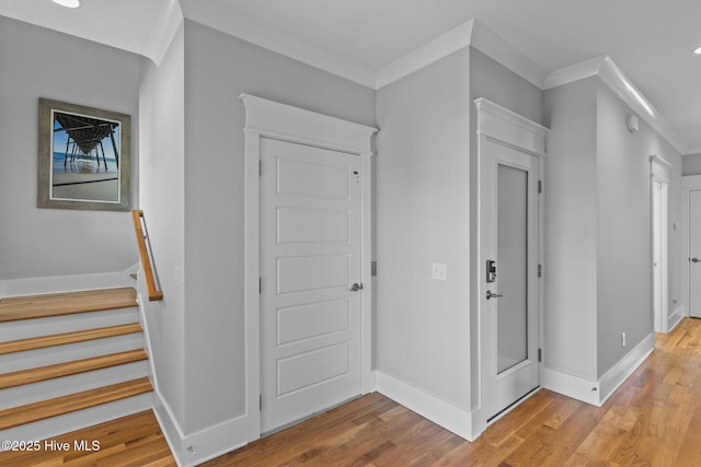 hallway featuring crown molding, recessed lighting, light wood-style floors, and baseboards