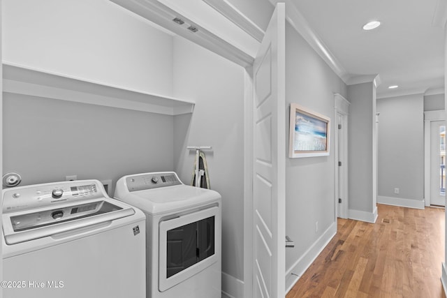 washroom featuring independent washer and dryer, laundry area, light wood-style flooring, recessed lighting, and ornamental molding