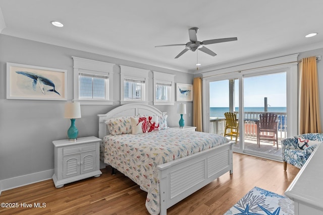 bedroom featuring a water view, access to outside, recessed lighting, and light wood-style flooring