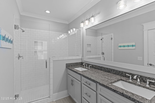 bathroom with double vanity, a sink, a stall shower, and recessed lighting