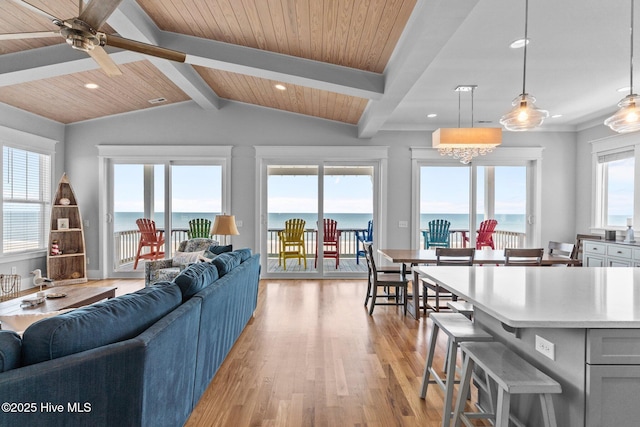 living area featuring ceiling fan, light wood finished floors, a water view, vaulted ceiling with beams, and recessed lighting