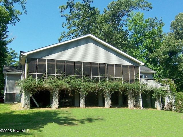 back of property with a lawn and a sunroom