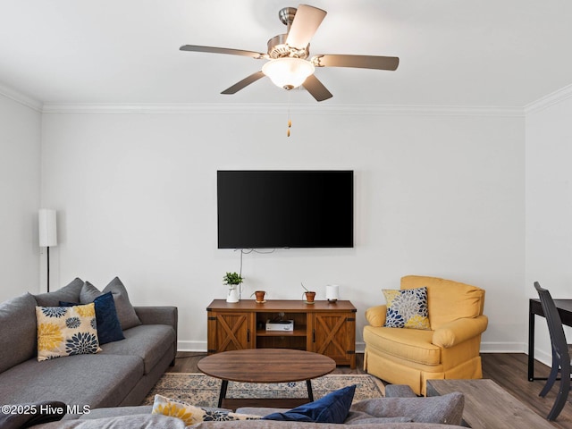 living area featuring ornamental molding, baseboards, ceiling fan, and wood finished floors