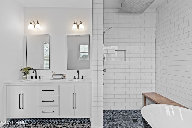 bathroom featuring a soaking tub, walk in shower, double vanity, and a sink