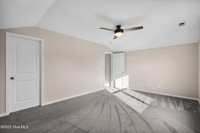 unfurnished bedroom with carpet flooring, visible vents, baseboards, and lofted ceiling