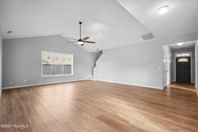 unfurnished living room with a ceiling fan, visible vents, vaulted ceiling, light wood finished floors, and stairs