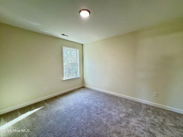 carpeted empty room featuring visible vents and baseboards