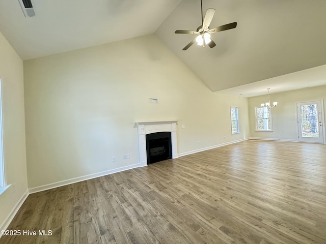 unfurnished living room featuring wood finished floors, a fireplace, baseboards, and high vaulted ceiling