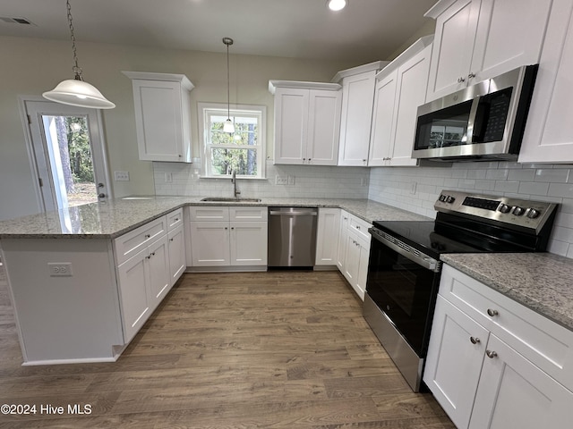 kitchen featuring white cabinetry, a peninsula, stainless steel appliances, and a sink