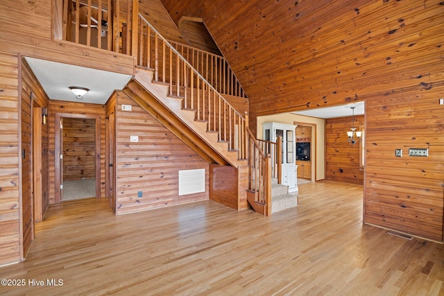 interior space featuring visible vents, wood walls, stairs, wooden ceiling, and light wood-style floors