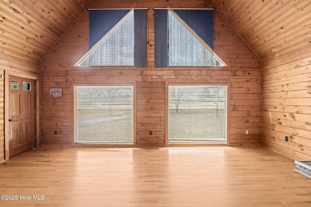 unfurnished living room with wood walls, wooden ceiling, and high vaulted ceiling