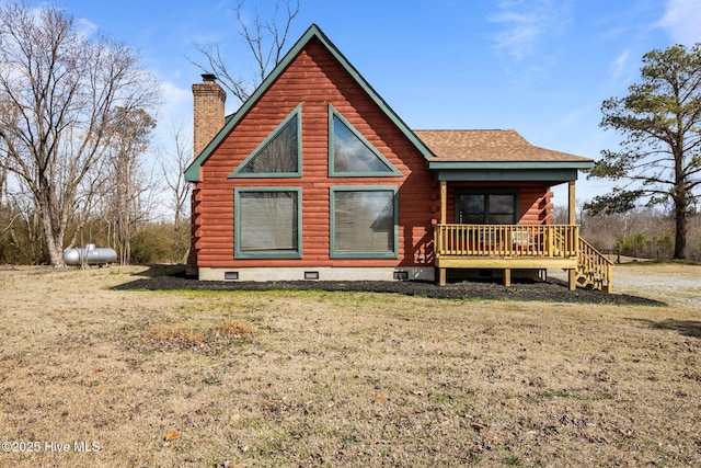 back of house featuring log siding, crawl space, a chimney, and a yard