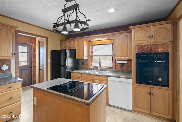 kitchen with a textured ceiling, black appliances, a center island, and a sink