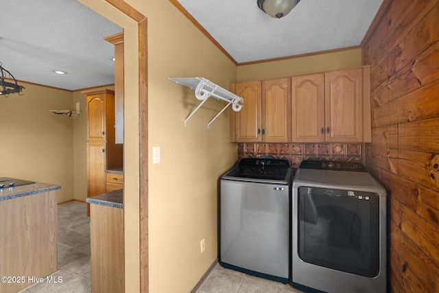 washroom featuring crown molding, light tile patterned flooring, cabinet space, and independent washer and dryer