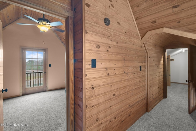 hall with wood ceiling, carpet floors, wooden walls, and lofted ceiling