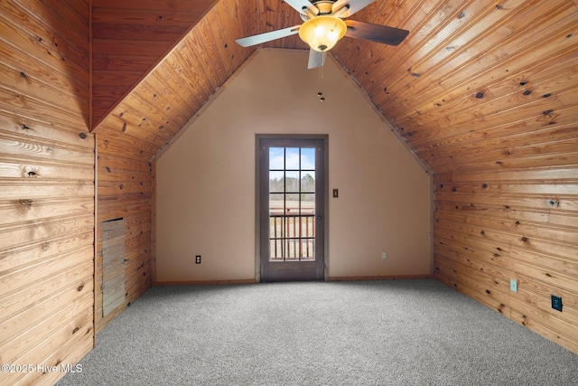 additional living space with wooden walls, a ceiling fan, carpet, vaulted ceiling, and wooden ceiling