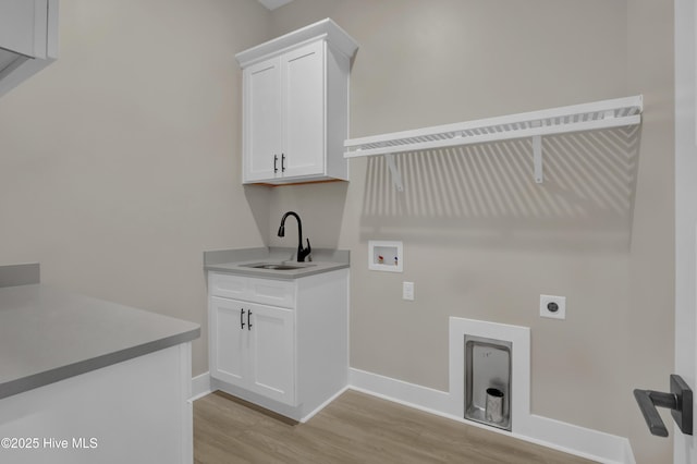 laundry area with light wood-type flooring, washer hookup, cabinet space, hookup for an electric dryer, and a sink