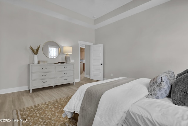 bedroom featuring light wood finished floors and baseboards