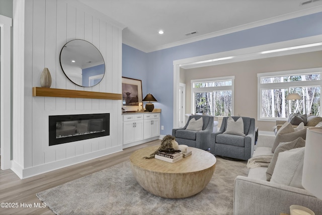 living room with recessed lighting, visible vents, a large fireplace, and light wood-style floors