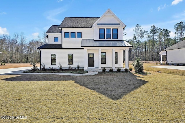 modern farmhouse featuring board and batten siding, a front lawn, a standing seam roof, and metal roof